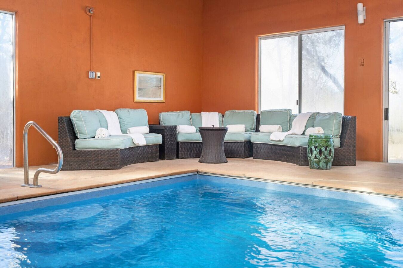Un área junto a la piscina con un espacio de descanso y una pileta.