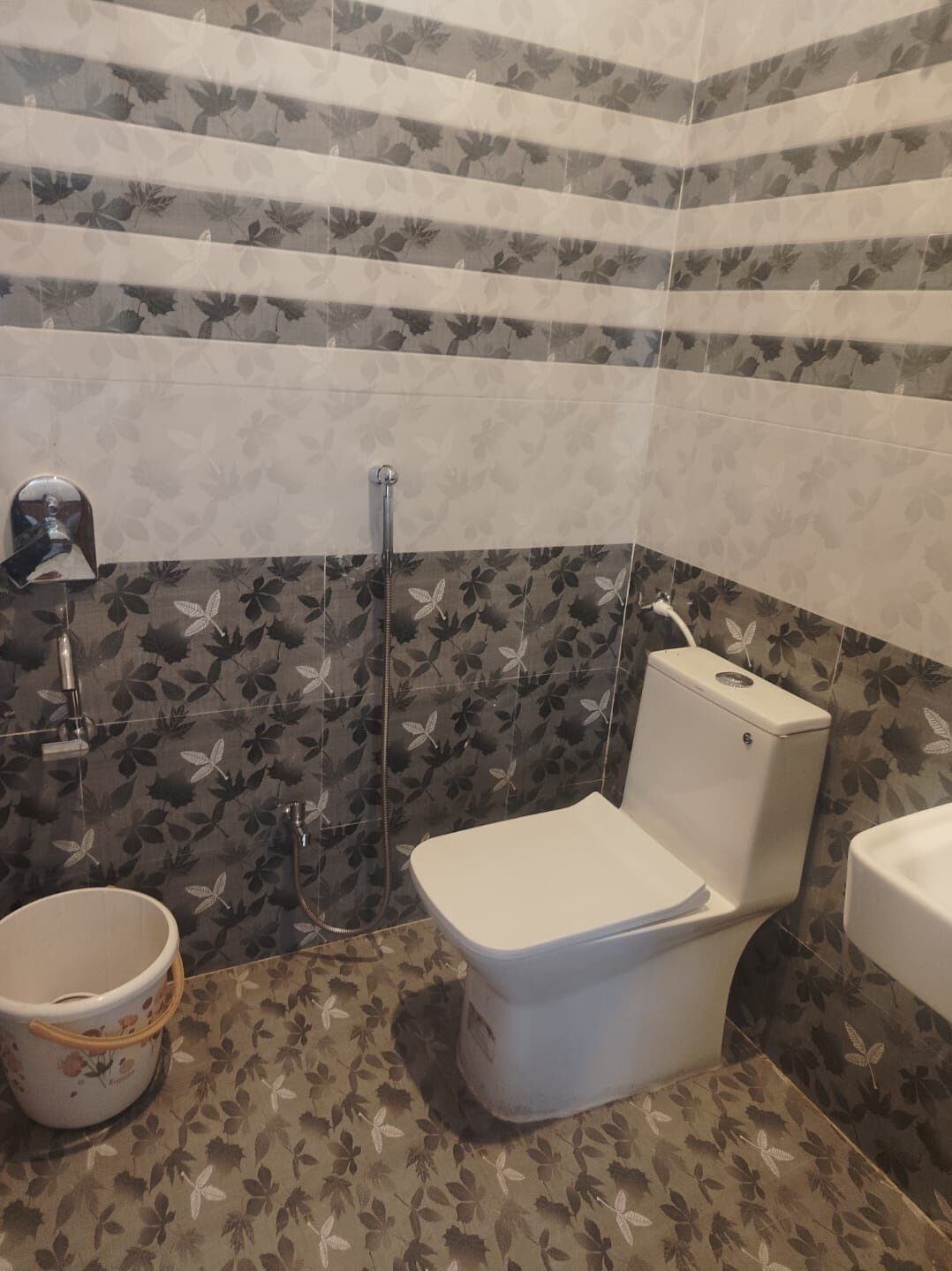 A bathroom with a toilet, bidet, and a sink.