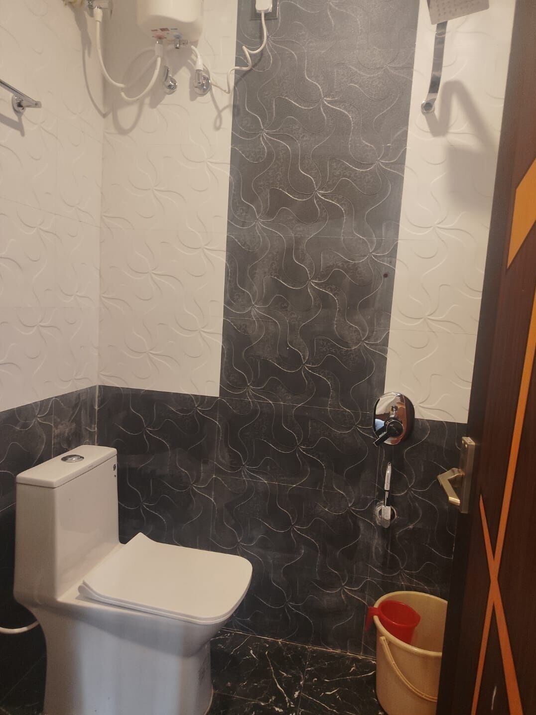 A bathroom with a toilet, a bidet, and a shower.