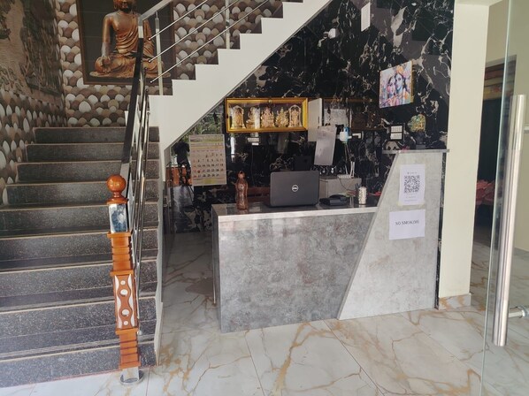 A hotel reception area with a marble staircase, a reception desk, and a statue. - BKP Jungle Resorts (Yercaud)