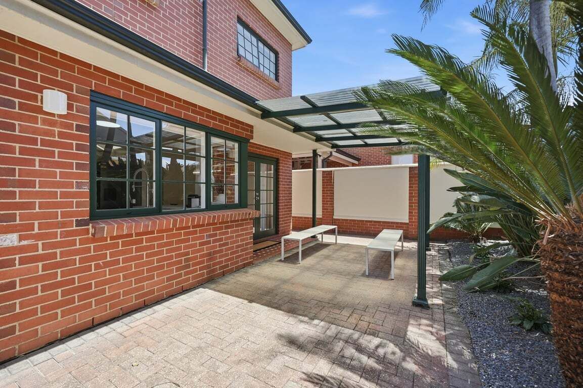 Een bakstenen gebouw met grote ramen en een overdekte patio.