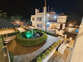 Un patio con una fuente, una piscina y un edificio moderno con balcones.