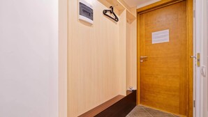 A wooden door with a handle and a keyhole, a small sign on the wall, and a wooden floor. - Compact Romantic Studio for couple (located in semi semi-basement) (Riga)
