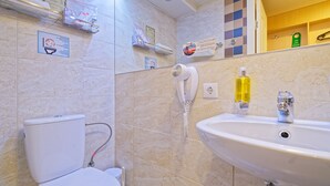 A bathroom with a toilet, a hand dryer, a sink, and a mirror. - Compact Romantic Studio for couple (located in semi semi-basement) (Riga)