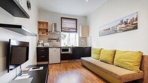 Een moderne keuken met een zithoek, een bank en een flatscreen-televisie.