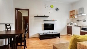 A compact living space with a dining area, a TV, a kitchen, and a door leading to another room. - One bedroom Twin apartment in the center of Riga (Riga)