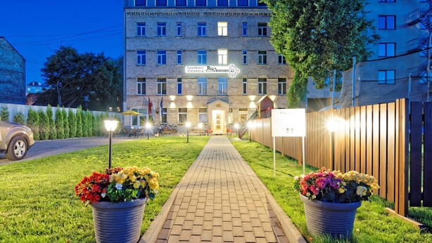 A hotel with a brick facade, multiple windows, and a paved pathway leading to the entrance. - Two bedrooms, Two double beds, 8 persons (Riga)