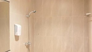 Een badkamer met een douche, een blauwe wastafel en een spiegel.