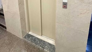 A closed elevator door with a control panel on the wall. - Hotel Grand Soma (Nagpur)