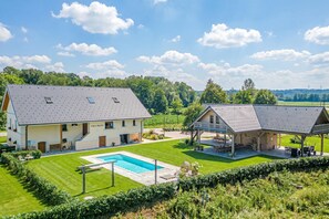 A two-story house with a swimming pool, a covered patio, and a well-maintained lawn. - Vila Trate Apartments (Križevci)