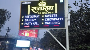 A signboard for 'The Royal Taste' with services like restaurant, bakery, party hall, sweets, chowpatty, and catering. - Raj Gharana (Raipur)