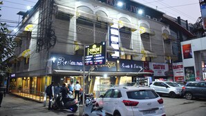 A hotel with a signboard advertising various amenities like a restaurant, bakery, and party hall. - Raj Gharana (Raipur)