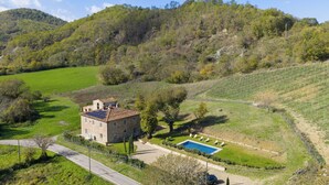 A stone house with a swimming pool, surrounded by green fields and trees. - Country House / Farm House in Olmi with 5 bedrooms sleeps 10 (Olmi)