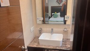 Une petite salle de bain avec un lavabo blanc, un miroir et une porte en bois.