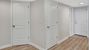 A hallway with white doors and wooden flooring.