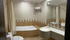 Un bagno con una vasca, un water e un lavandino.