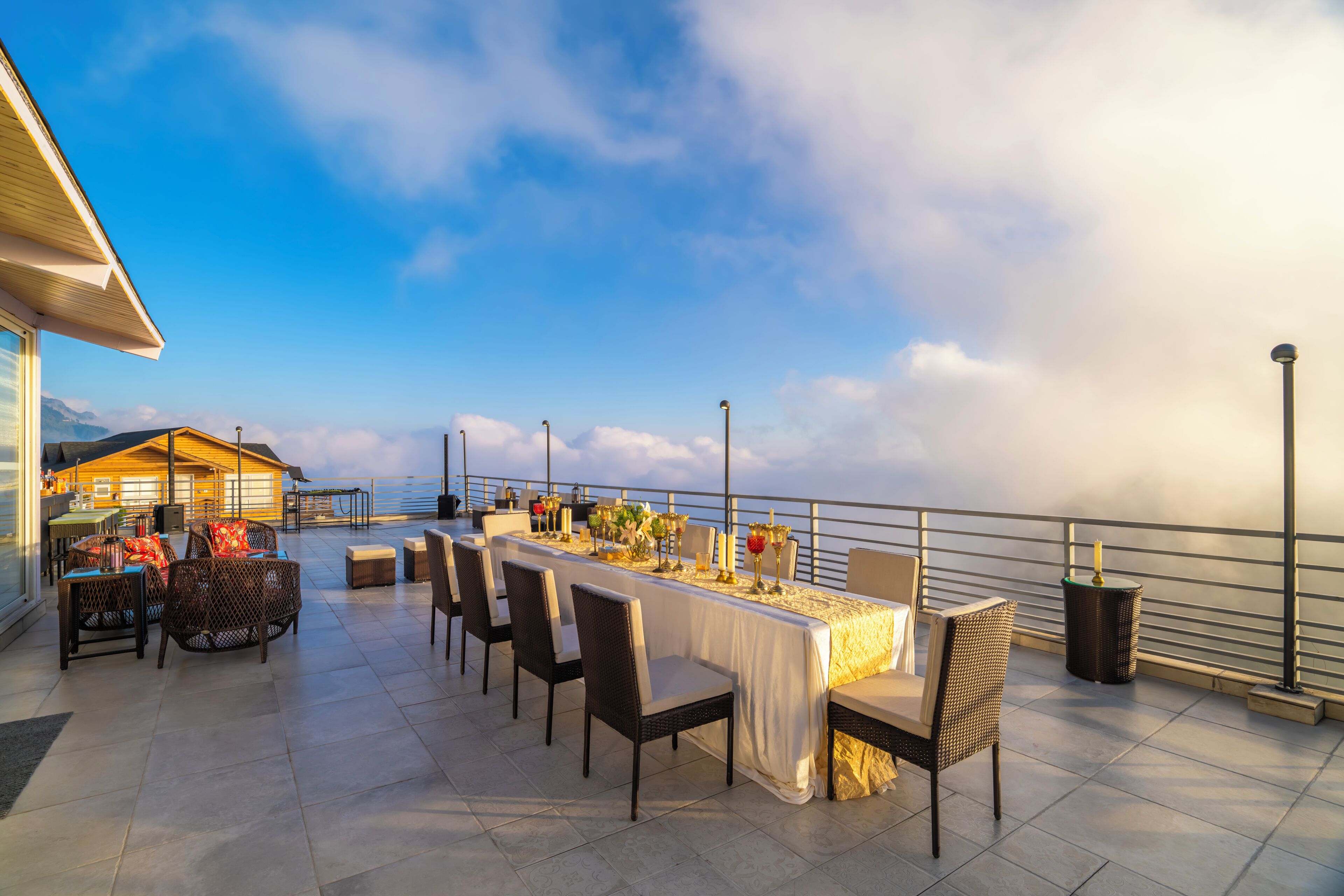 An outdoor dining area with a long table, chairs, and a view of the ocean.
