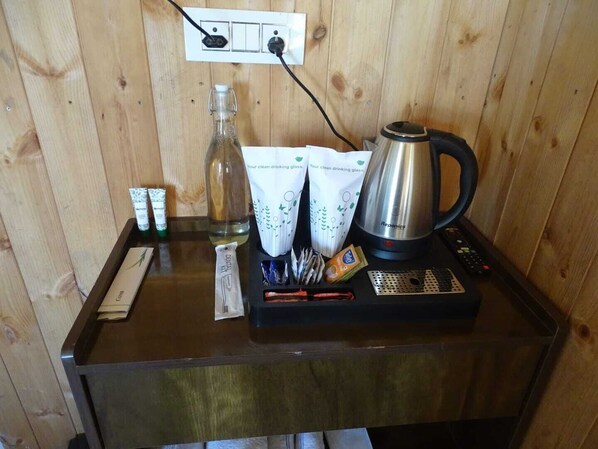 A wooden wall with a power outlet and a Reptonics coffee maker on a table. - Shiku Glamping Stays (Dhanaulti)