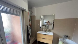 Ein Badezimmer mit Dusche, Waschbecken und Badewanne.