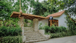 A stone staircase leading to a house with a tiled roof, surrounded by lush greenery. - Nuansa Penida Cottage (Penida Island)