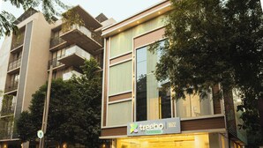 A modern building with a 'treebo bizz premium' sign, featuring balconies and a large window. - Treebo Premium Bizz (Ahmedabad)