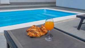 A poolside table with croissants and a glass of orange juice. - Gorgeous home in Primosten (Primosten)