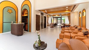 Eine Hotelhalle mit einer Rezeption, einer Sitzecke und Blick auf den Speisesaal.