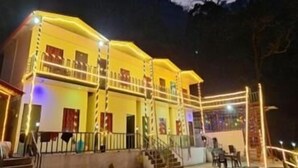 A two-story building with a balcony, stairs leading to the entrance, and a railing around the balcony. - Haveli Resort Shivpuri (Rishikesh)