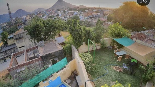 Zona residencial con piscina, lona verde y manguera.
