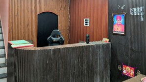 Una recepción con detalles de madera, un ventilador de techo y un televisor con marco negro en la pared.