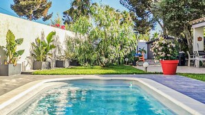 A swimming pool with a curved edge, surrounded by a well-maintained lawn and various plants. - Awesome home in Six-Fours-les-Plages (Six-Fours-les-Plages)