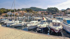A marina with numerous boats docked, surrounded by residential buildings and hills in the background. - Awesome home in Six-Fours-les-Plages (Six-Fours-les-Plages)