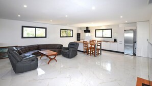 A spacious living area with a sectional sofa, a wooden coffee table, and a dining set. - Villa avec piscine privée (Portel des Corbières)
