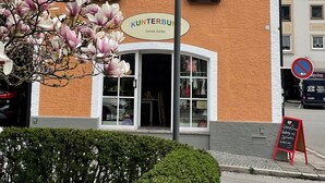 A building with a sign reading "KUNTERBUN" and a shop window displaying items. - Vacation apartment Kunterbunt (Bad Reichenhall)