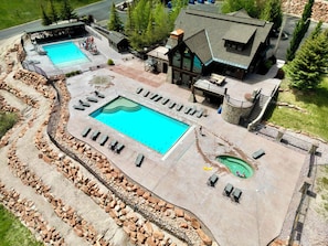 A large outdoor swimming pool with multiple lounge chairs and a stone pathway.