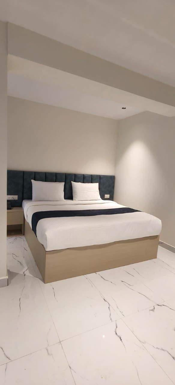 A modern bedroom with a bed, nightstand, and a light fixture.