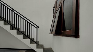 Una escalera con barandilla negra que conduce a un rellano.