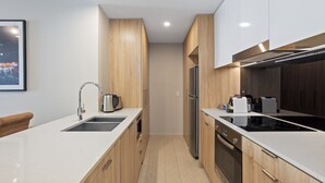 Eine moderne Küche mit Kochinsel, Edelstahlgeräten und Holzausstattung.