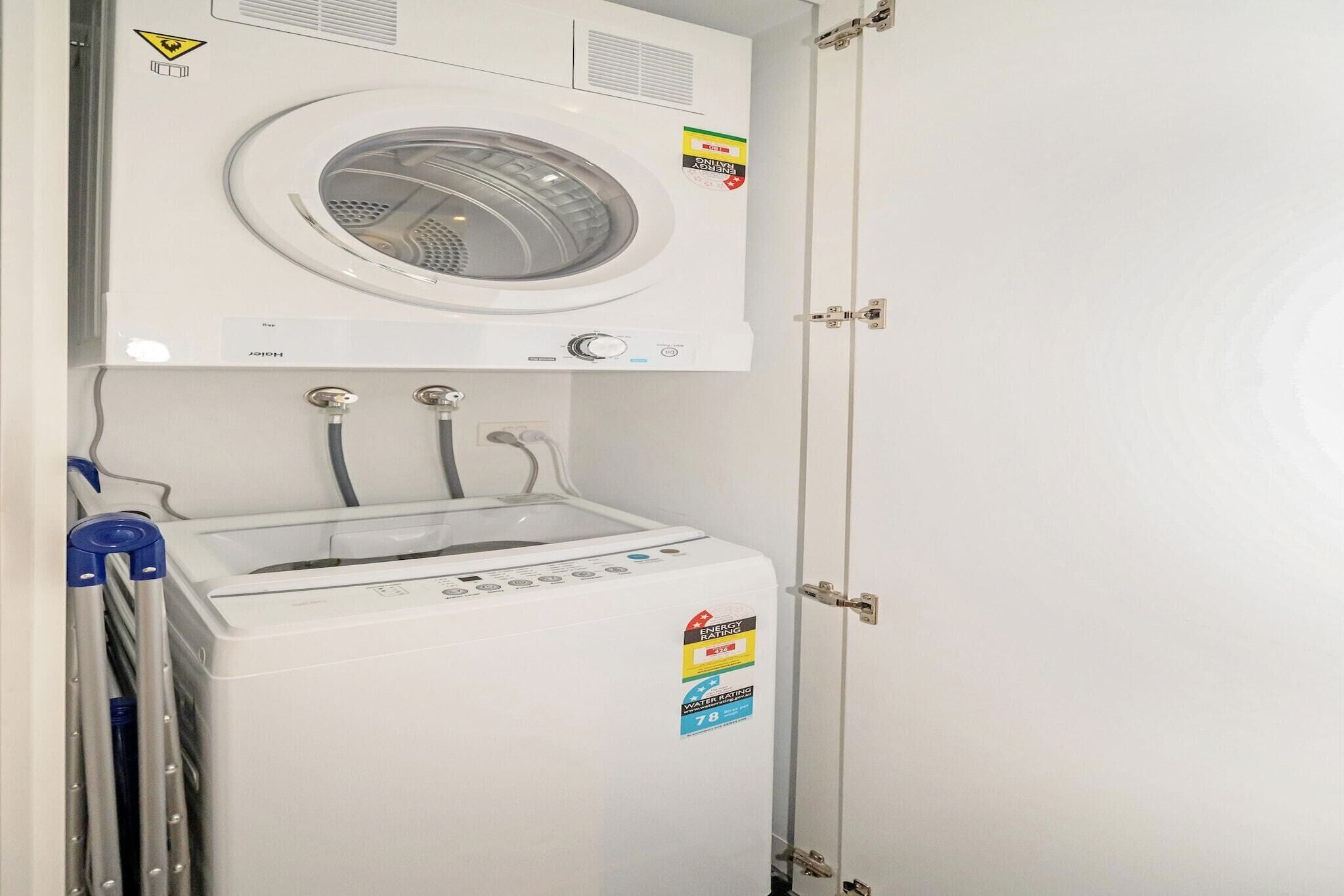 Eine Waschmaschine und ein Trockner im Frontlader-Design, mit Sicherheitshinweis, Energieeffizienz-Kennzeichnung und Wasserverbrauchskennzeichnung.