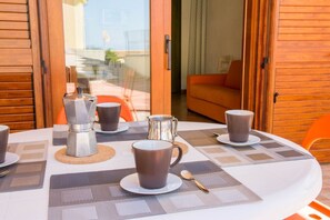 Een eettafel gedekt met koffiekopjes, een koffiepot en een suikerpot.