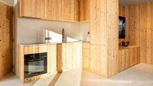 Une cuisine moderne avec des meubles en bois, un four encastré et un évier.
