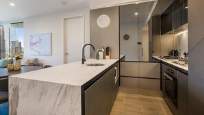 Een moderne keuken met een centraal eiland, roestvrijstalen apparatuur en uitzicht over de stad.