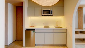 A compact kitchen with a built-in microwave, a sink, and a dishwasher. - TOP The Raven Double | Modern 2BR apartment (Mexico City)