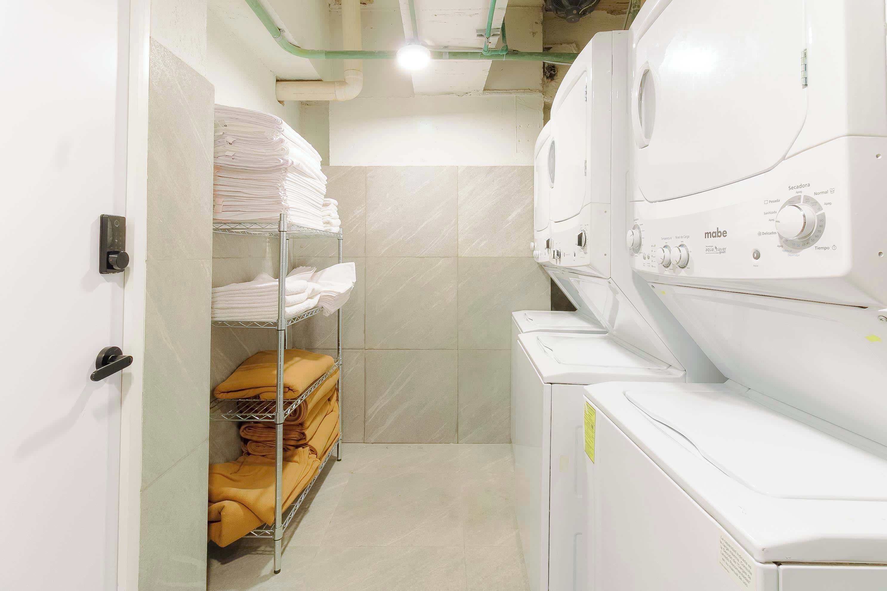 A laundry room with stacked towels and a washing machine.