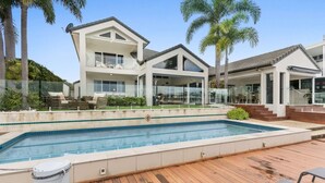Una casa moderna con piscina, ampie finestre e terrazza.