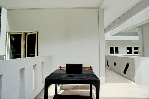 A minimalist room with a table, a bench, and a laptop. - OYO 95041 Griya Indah Homestay (Surabaya)