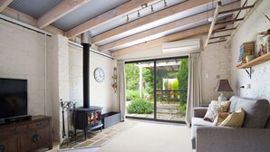 Una sala de estar acogedora con chimenea, televisión y sofá.