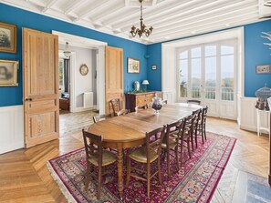 A dining room with a wooden table and chairs, a large window, and a view of the outdoors. - Manor with Terrace and Pool for 12 Guests (Saint-Léon-sur-Vézère)