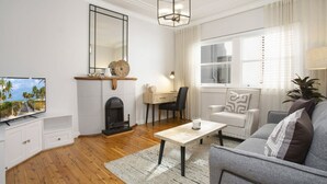 Una sala de estar con chimenea, televisión, escritorio y sofá.