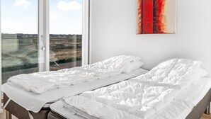 A bedroom with a large window, a bed, and a painting on the wall. - "Saxi" - 650m from the sea by Interhome (Skagen)